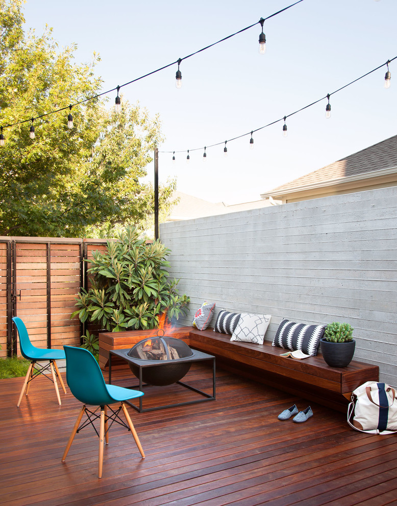 This is an example of a small contemporary backyard deck in Austin with a fire feature and no cover.
