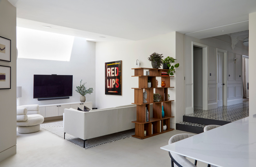 На фото: огромная гостиная комната в современном стиле с бежевыми стенами, бетонным полом, телевизором на стене и обоями на стенах с