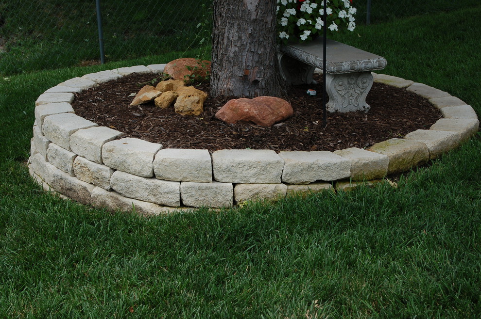 Photo of a small traditional shade backyard mulch retaining wall landscape.