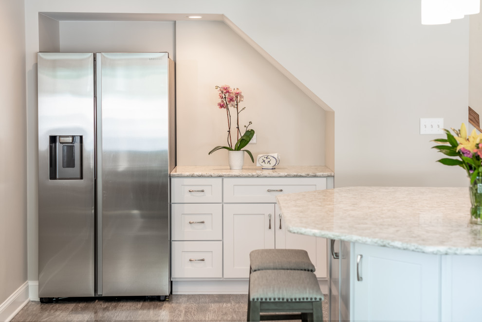 This is an example of a mid-sized transitional l-shaped kitchen in Philadelphia with an undermount sink, shaker cabinets, white cabinets, quartz benchtops, stainless steel appliances and with island.