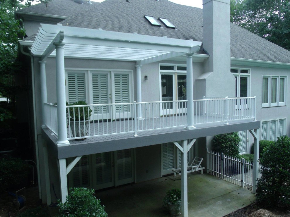 Design ideas for a mid-sized beach style backyard deck in Charlotte with a pergola.