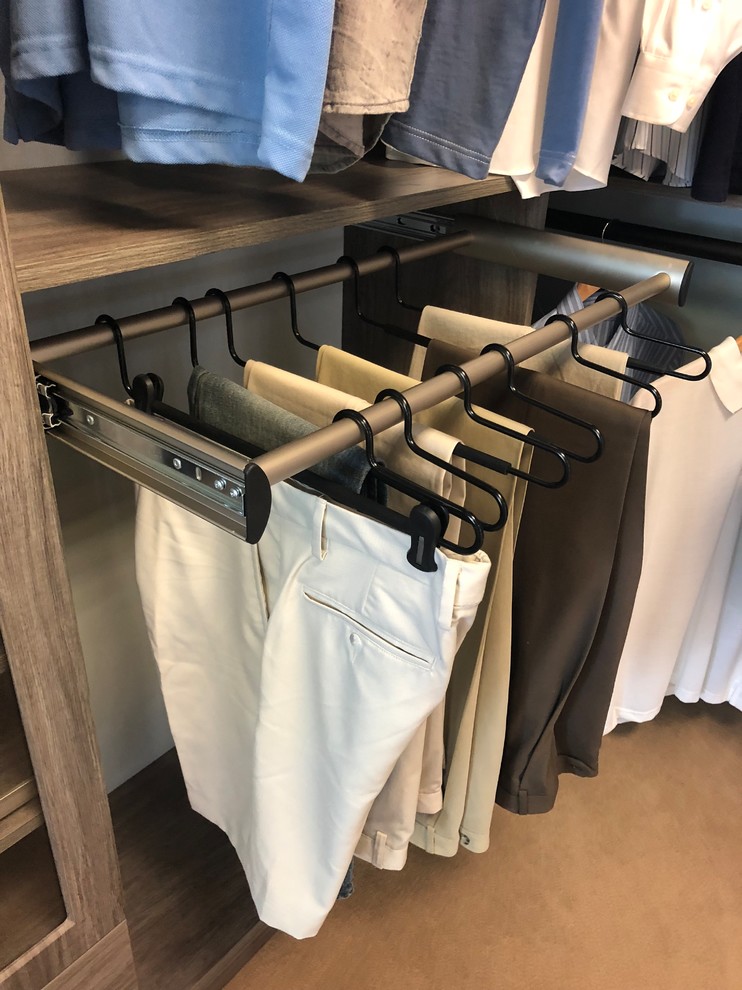 Transitional carpeted walk-in closet photo with flat-panel cabinets and gray cabinets