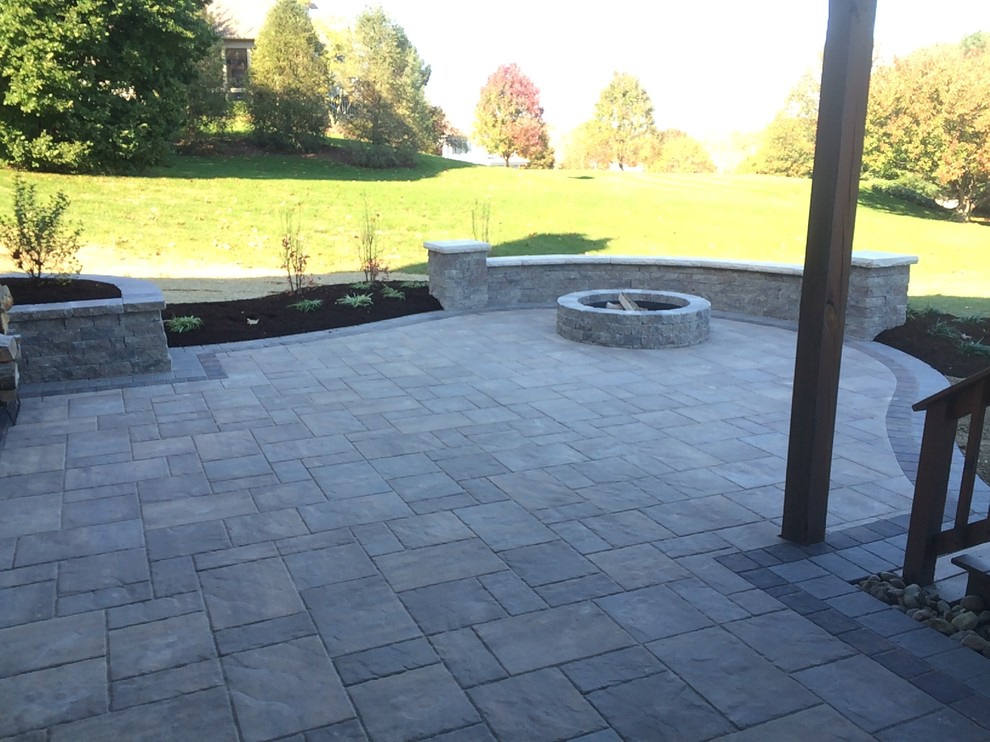 This is an example of a mid-sized traditional backyard patio in Philadelphia with natural stone pavers and no cover.
