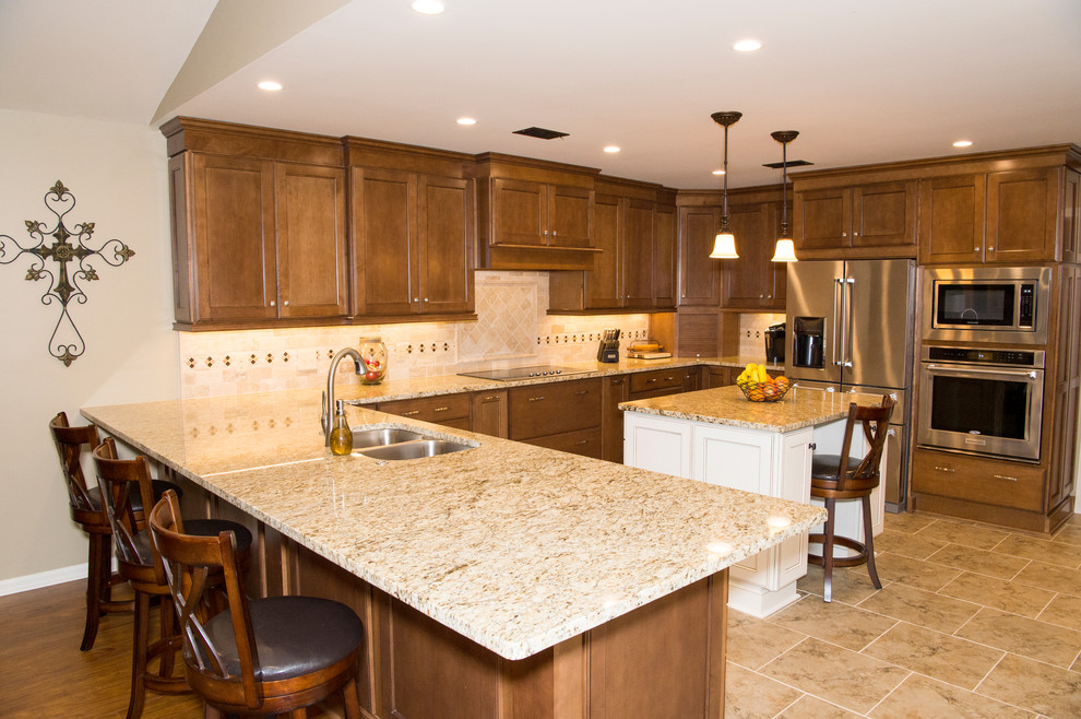 Example of a huge transitional u-shaped porcelain tile eat-in kitchen design in Little Rock with a double-bowl sink, raised-panel cabinets, dark wood cabinets, quartzite countertops, beige backsplash, stone tile backsplash, stainless steel appliances and an island