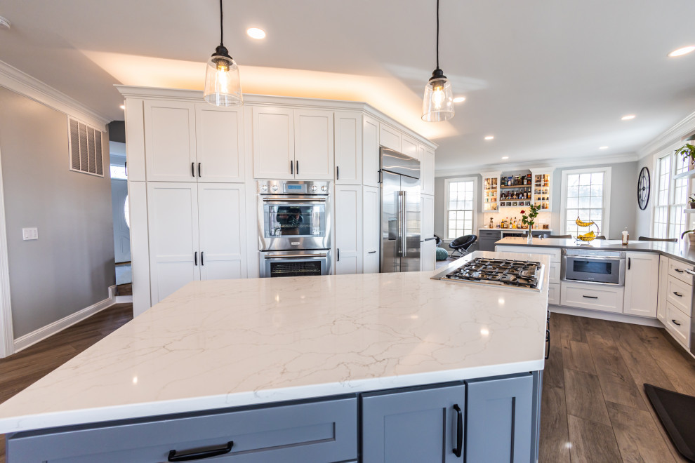Inspiration for a large transitional vinyl floor and brown floor kitchen remodel in Baltimore with an undermount sink, shaker cabinets, white backsplash, porcelain backsplash, stainless steel appliances, an island and white countertops