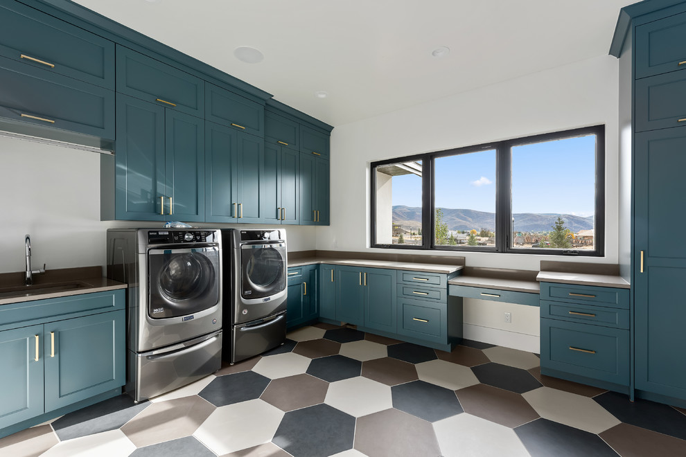 Inspiration for an expansive contemporary l-shaped dedicated laundry room in Salt Lake City with an undermount sink, shaker cabinets, blue cabinets, quartz benchtops, white walls, porcelain floors, a side-by-side washer and dryer, multi-coloured floor and beige benchtop.