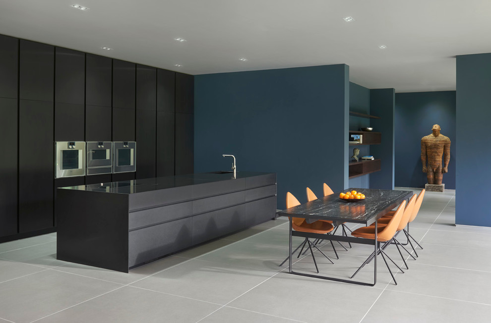 Contemporary single-wall open plan kitchen in London with an integrated sink, flat-panel cabinets, black cabinets, granite benchtops, panelled appliances and with island.