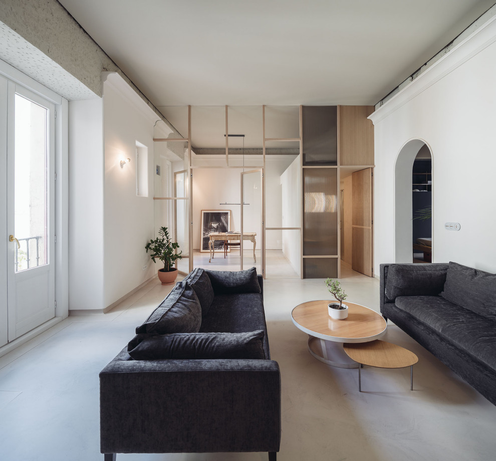 This is an example of a mid-sized modern open concept living room in Madrid with concrete floors, beige floor and white walls.