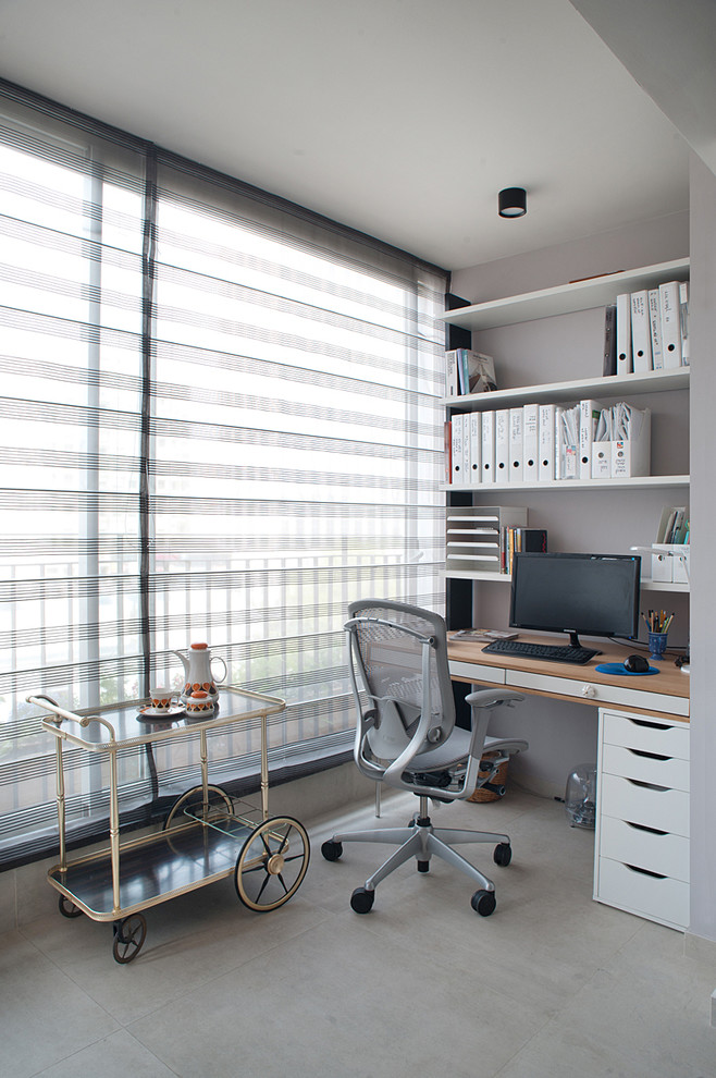 This is an example of a contemporary home office in Tel Aviv with grey walls, no fireplace and a built-in desk.