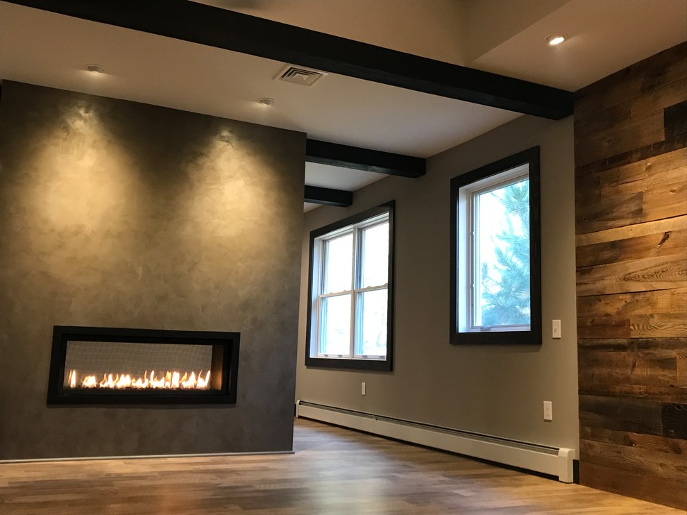 This is an example of a large country master bedroom in Philadelphia with a two-sided fireplace, grey walls, medium hardwood floors and brown floor.