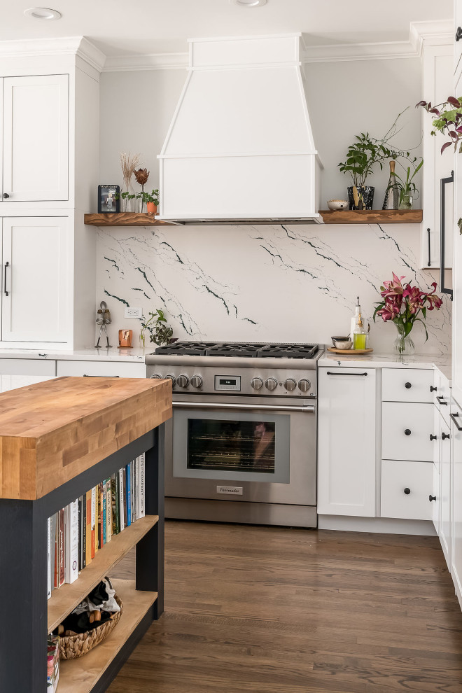 Mid-sized transitional l-shaped medium tone wood floor and brown floor kitchen photo in Chicago with an undermount sink, shaker cabinets, white cabinets, quartz countertops, white backsplash, quartz backsplash, paneled appliances, an island and white countertops