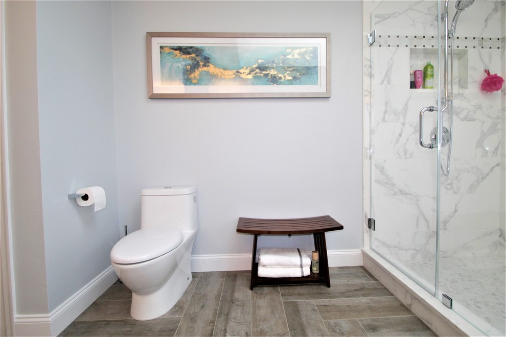 Photo of a mid-sized transitional master bathroom in New York with flat-panel cabinets, grey cabinets, a freestanding tub, a corner shower, a one-piece toilet, multi-coloured tile, porcelain tile, grey walls, porcelain floors, an undermount sink and quartzite benchtops.