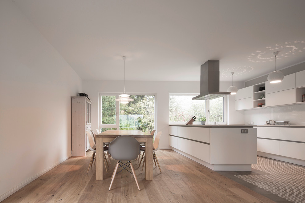 Mittelgroße Moderne Wohnküche mit weißer Wandfarbe und braunem Holzboden in Hamburg