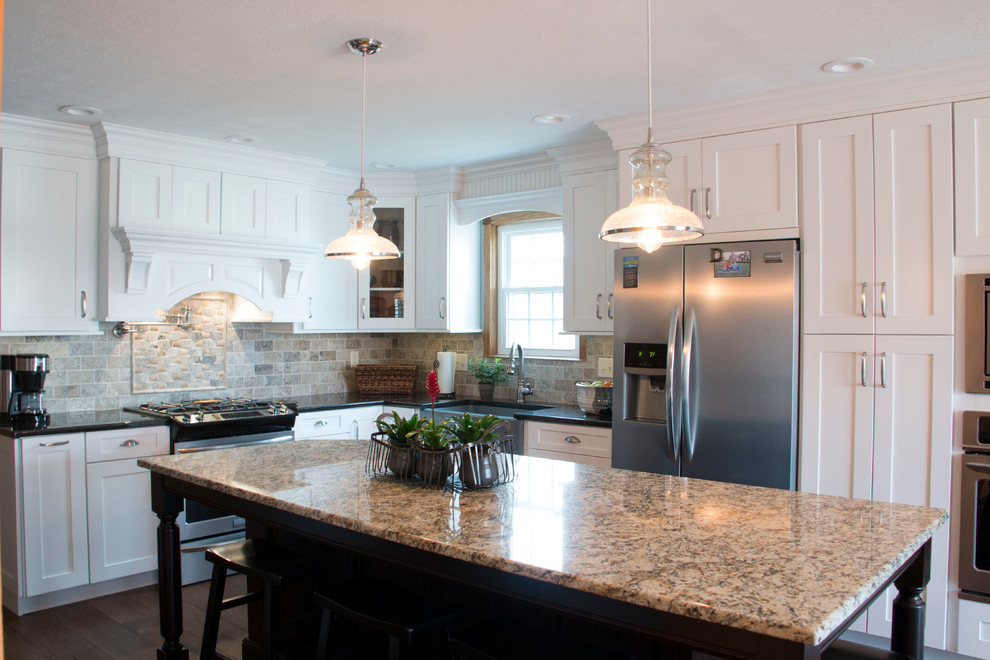 Example of a large transitional l-shaped medium tone wood floor eat-in kitchen design with an undermount sink, shaker cabinets, white cabinets, granite countertops, gray backsplash, stone tile backsplash, stainless steel appliances and an island