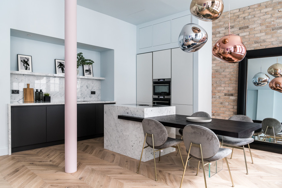 Photo of a contemporary u-shaped eat-in kitchen in London with an undermount sink, flat-panel cabinets, white cabinets, multi-coloured splashback, panelled appliances, medium hardwood floors, with island, brown floor and multi-coloured benchtop.