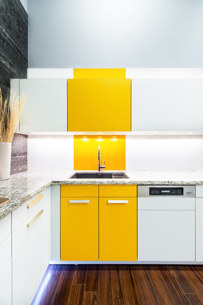 Design ideas for a contemporary kitchen in Toronto with an undermount sink, flat-panel cabinets, yellow cabinets, solid surface benchtops, white splashback and panelled appliances.