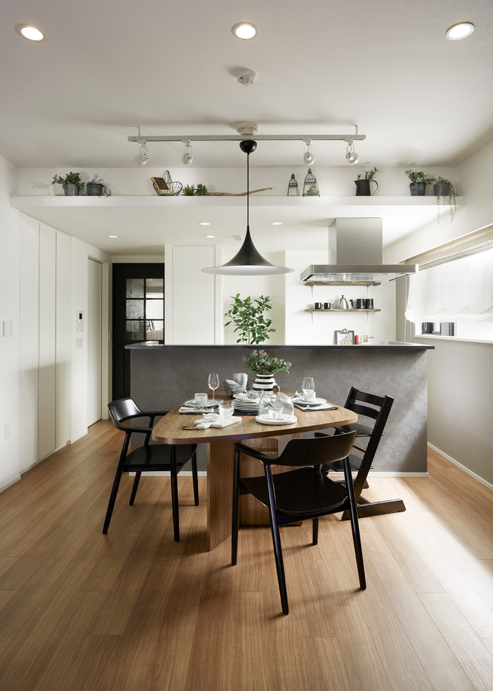 Inspiration for a contemporary dining room in Tokyo with white walls and light hardwood floors.