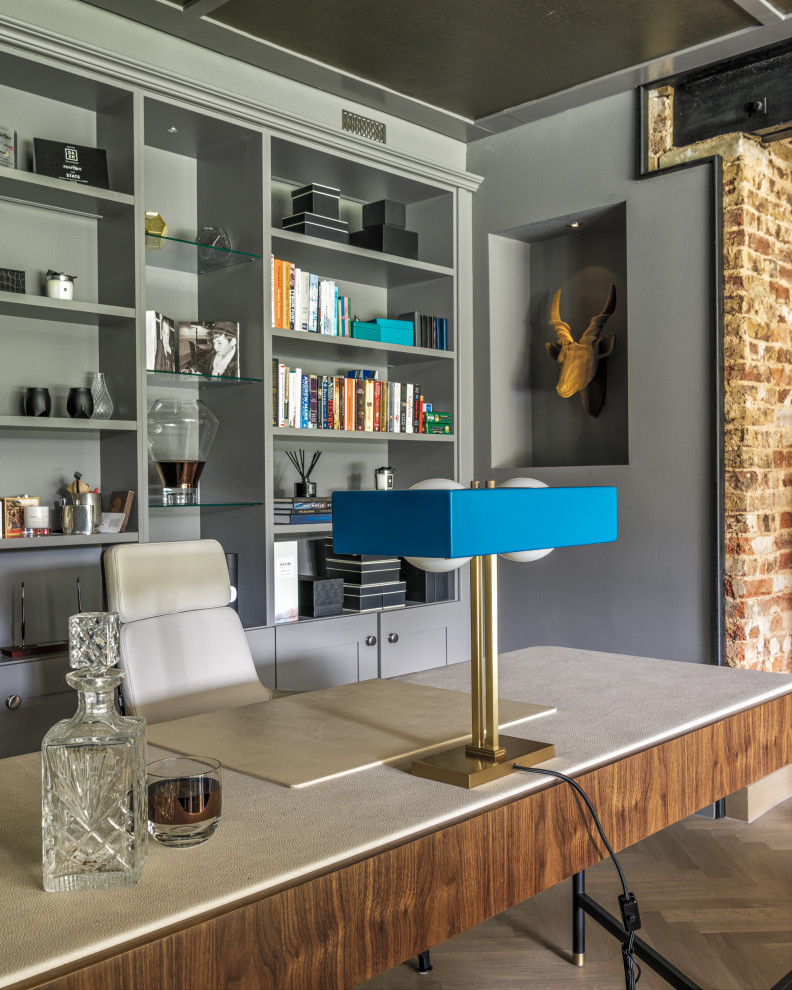 Modelo de despacho contemporáneo de tamaño medio con paredes grises, marco de chimenea de ladrillo, suelo gris, ladrillo, todas las chimeneas y escritorio independiente