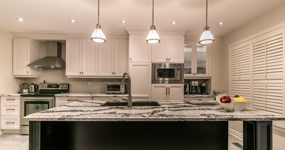 Inspiration for a large transitional gray floor enclosed kitchen remodel in Toronto with an undermount sink, recessed-panel cabinets, white cabinets, quartz countertops, white backsplash, ceramic backsplash, stainless steel appliances and an island