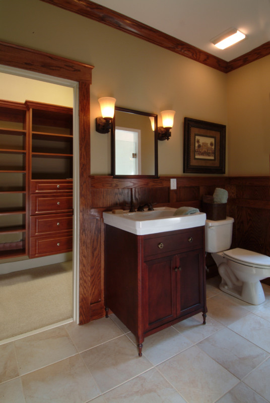 Photo of a mid-sized arts and crafts master bathroom in Atlanta with shaker cabinets, dark wood cabinets, beige floor, a curbless shower, a two-piece toilet, beige walls, porcelain floors, an integrated sink, a hinged shower door, white benchtops, a shower seat, a single vanity and a freestanding vanity.