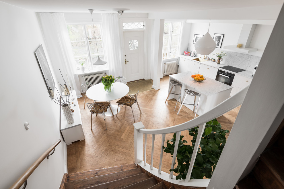 Idéer för ett mellanstort modernt grå kök, med en nedsänkt diskho, luckor med profilerade fronter, vita skåp, marmorbänkskiva, grått stänkskydd, stänkskydd i marmor, vita vitvaror, mellanmörkt trägolv och en köksö