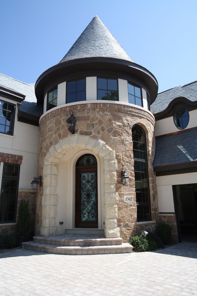 This is an example of a large mediterranean two-storey beige exterior in Milwaukee with mixed siding.