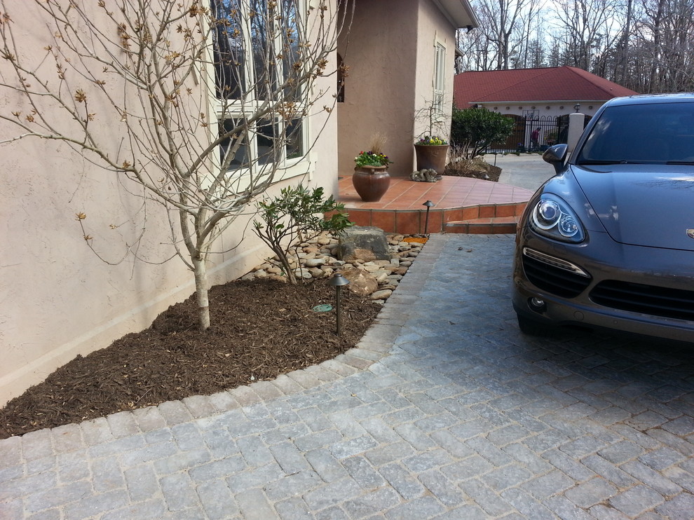 Design ideas for an expansive front yard driveway in Raleigh with concrete pavers.