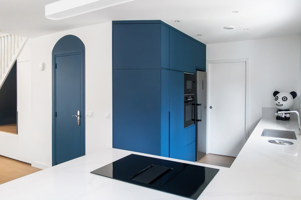 Esempio di una cucina scandinava di medie dimensioni con lavello a vasca singola, ante blu, top in granito, paraspruzzi bianco, paraspruzzi in granito, elettrodomestici in acciaio inossidabile, pavimento in linoleum e top bianco