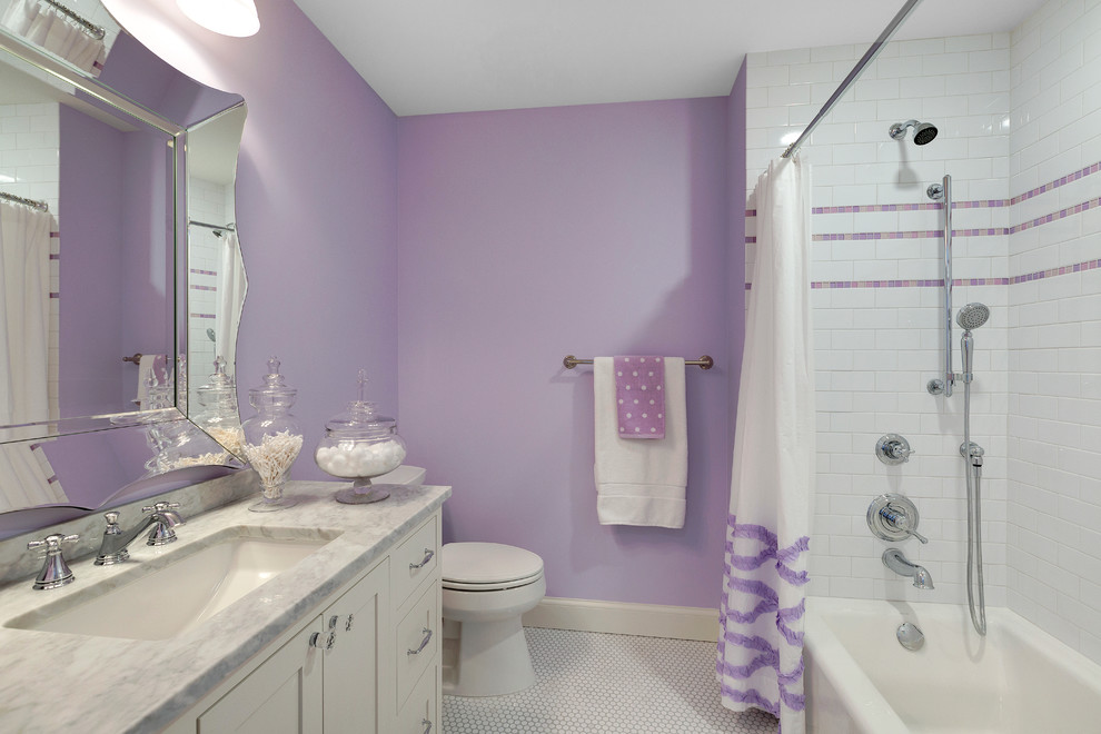 Photo of a large transitional kids bathroom in Minneapolis with recessed-panel cabinets, white cabinets, a freestanding tub, a shower/bathtub combo, white tile, purple walls, ceramic floors, an undermount sink and marble benchtops.