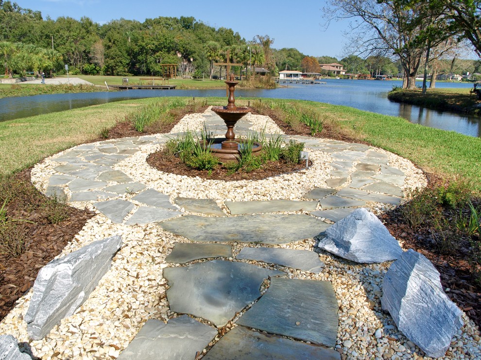 This is an example of a huge traditional full sun backyard stone landscaping in Orlando for fall.