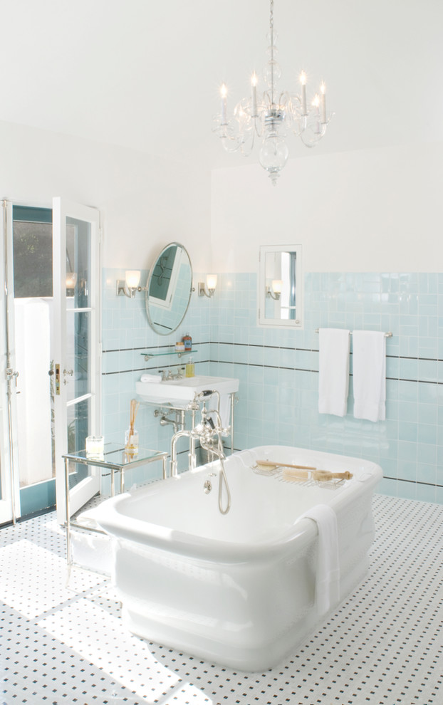 Photo of a large mediterranean master bathroom in Santa Barbara with flat-panel cabinets, a freestanding tub, blue tile, porcelain tile, white walls, porcelain floors and a pedestal sink.
