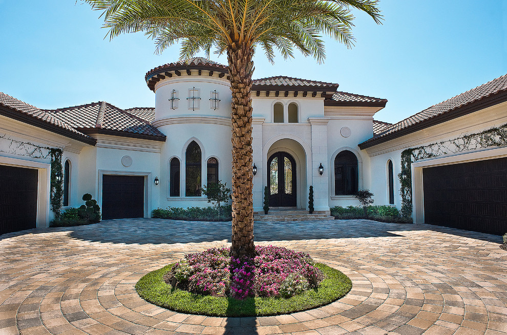Photo of an expansive mediterranean entryway in Miami with white walls, concrete floors, a double front door and a black front door.