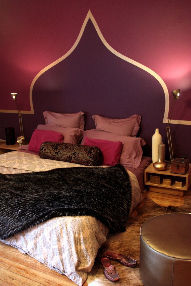 This is an example of a mid-sized eclectic master bedroom in New York with purple walls and medium hardwood floors.