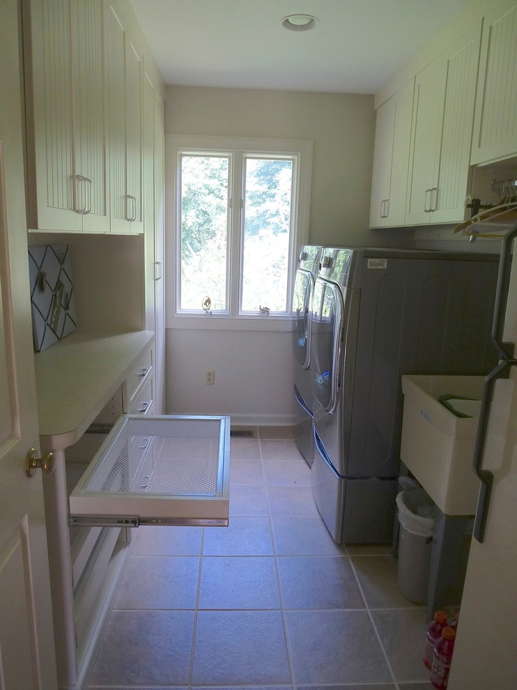 Mid-sized traditional galley laundry room in Other with an utility sink, beaded inset cabinets, beige cabinets, laminate benchtops and a side-by-side washer and dryer.