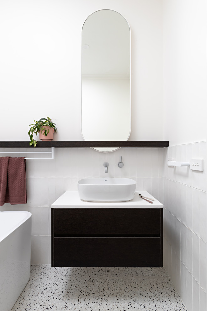 Design ideas for a contemporary bathroom in Melbourne with flat-panel cabinets, black cabinets, a freestanding tub, white tile, white walls, a vessel sink, white floor, white benchtops, a single vanity and a floating vanity.