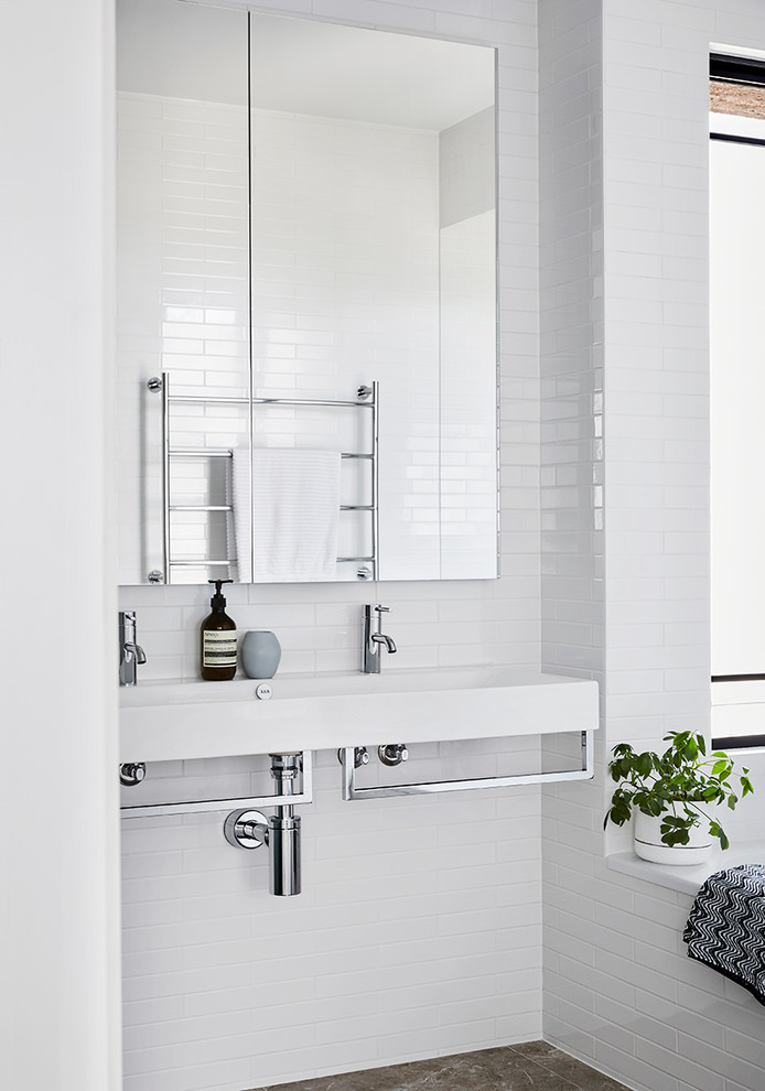Mid-sized contemporary bathroom in Melbourne with white cabinets, subway tile, white walls, marble floors, a wall-mount sink, white benchtops, a freestanding tub, white tile and an open shower.