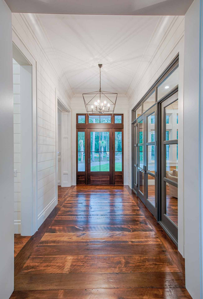 おしゃれな玄関ドア (白い壁、濃色無垢フローリング、濃色木目調のドア、茶色い床、塗装板張りの壁) の写真
