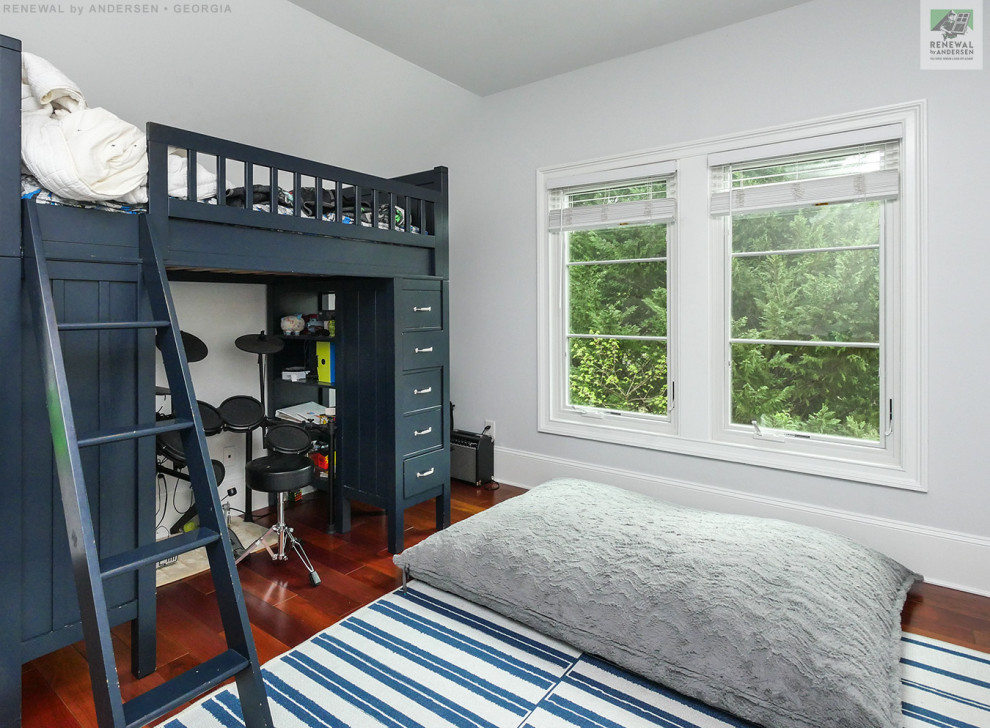 Bild på ett mellanstort pojkrum kombinerat med sovrum och för 4-10-åringar, med vita väggar, mörkt trägolv och flerfärgat golv