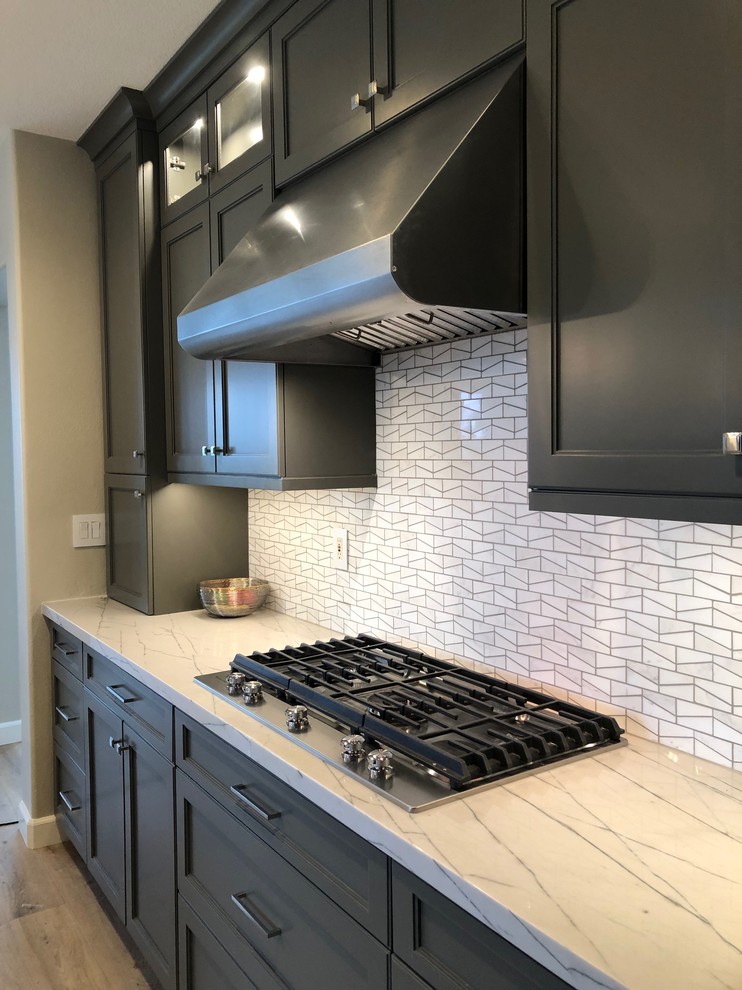 Design ideas for a large contemporary l-shaped eat-in kitchen in Orange County with an undermount sink, recessed-panel cabinets, grey cabinets, quartzite benchtops, white splashback, mosaic tile splashback, stainless steel appliances, vinyl floors, with island, beige floor and white benchtop.