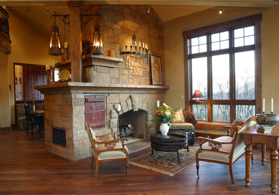 Photo of an expansive country open concept living room in Salt Lake City with beige walls, dark hardwood floors, a two-sided fireplace, a stone fireplace surround and no tv.