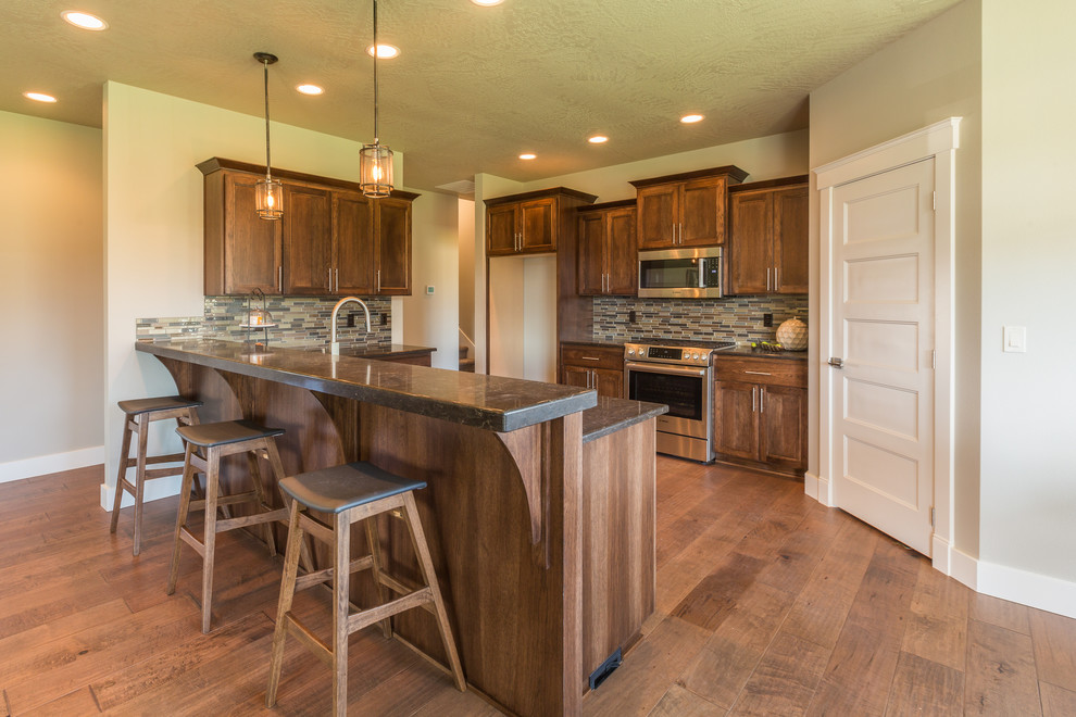 Mid-sized transitional l-shaped dark wood floor and brown floor open concept kitchen photo in Seattle with a double-bowl sink, recessed-panel cabinets, dark wood cabinets, granite countertops, multicolored backsplash, matchstick tile backsplash, stainless steel appliances and an island