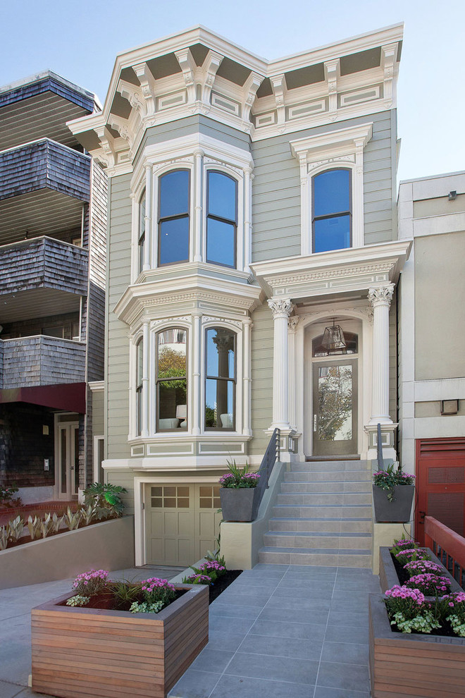 Inspiration for a traditional two-storey grey house exterior in San Francisco with vinyl siding and a flat roof.