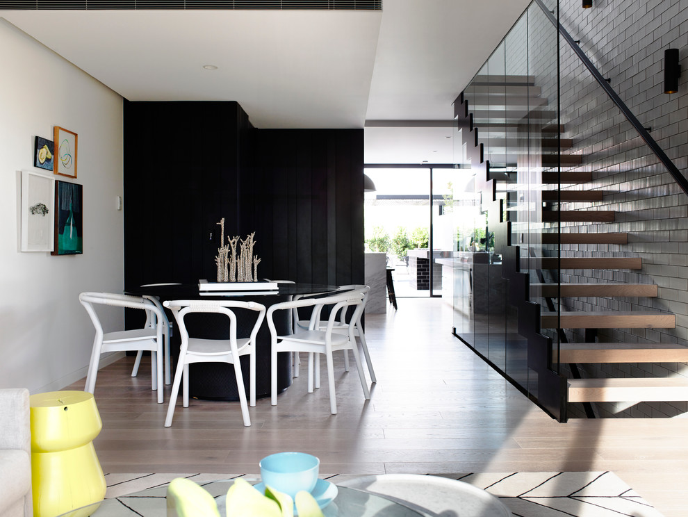 Photo of a contemporary open plan dining in Melbourne with white walls and light hardwood floors.