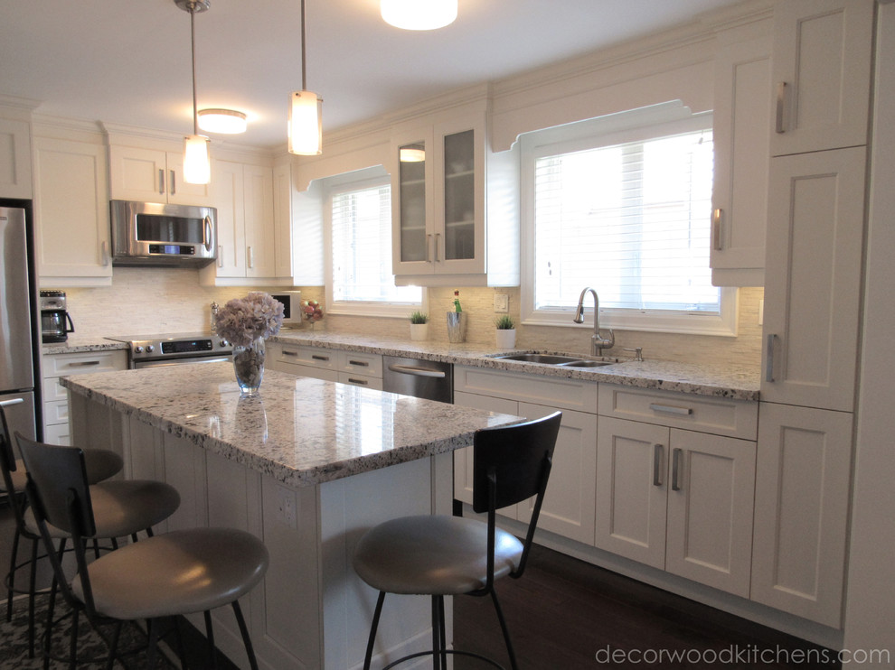 Example of a mid-sized transitional l-shaped dark wood floor enclosed kitchen design in Toronto with an undermount sink, flat-panel cabinets, white cabinets, granite countertops, white backsplash, stone tile backsplash, stainless steel appliances and an island