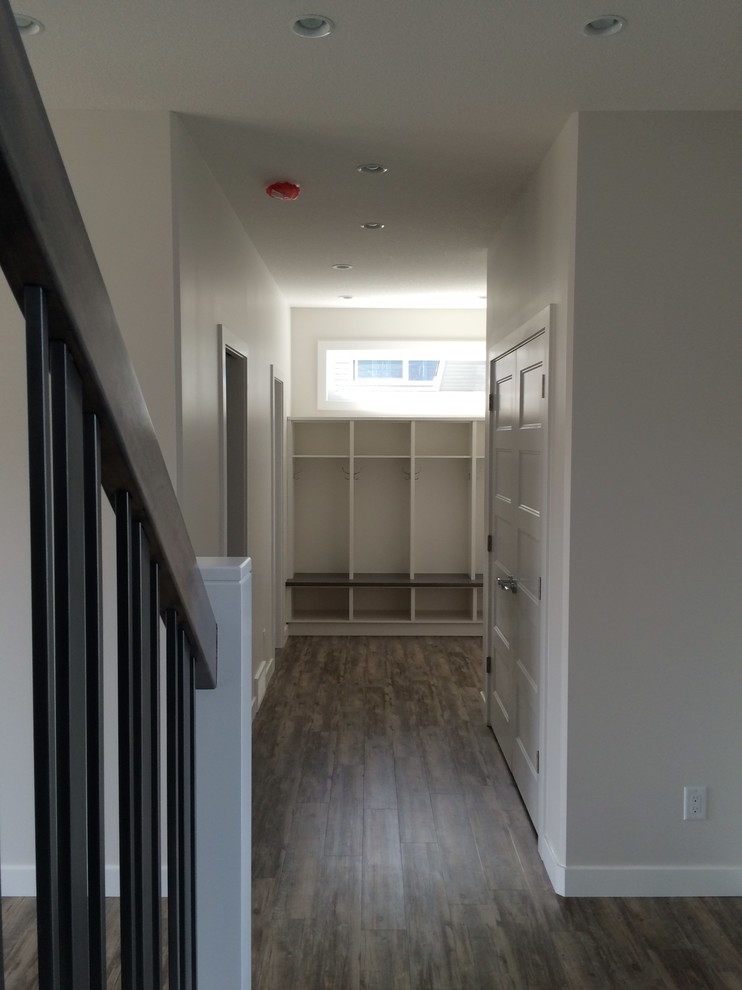 Mudroom - mid-sized transitional dark wood floor and brown floor mudroom idea in Calgary with gray walls