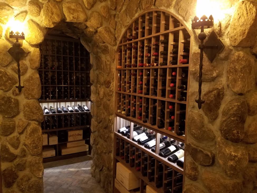 Inspiration for a large country wine cellar in Orange County with brick floors, storage racks and brown floor.