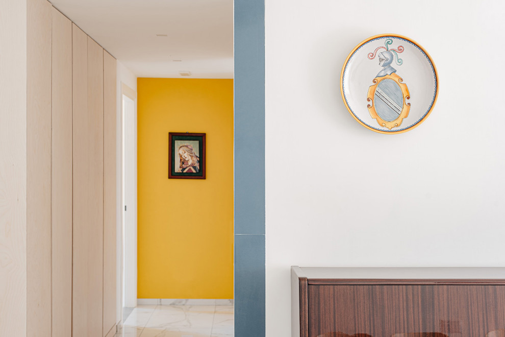 Ispirazione per un ingresso o corridoio minimal con pareti gialle, pavimento in gres porcellanato e pavimento bianco