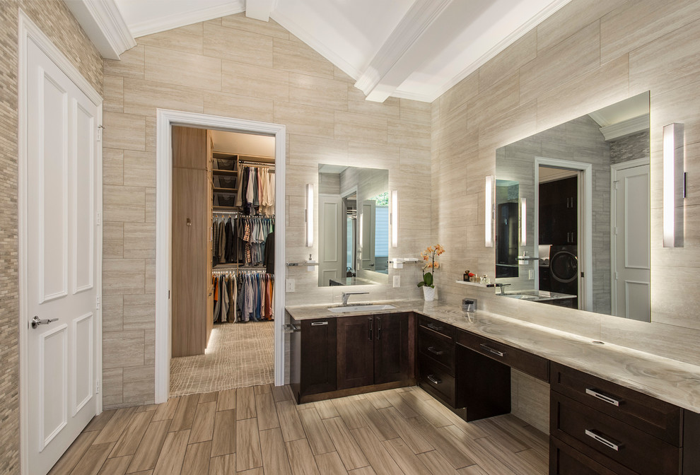 Inspiration for a large transitional master bathroom in Dallas with shaker cabinets, dark wood cabinets, a freestanding tub, a corner shower, beige tile, porcelain tile, beige walls, porcelain floors, an undermount sink and onyx benchtops.