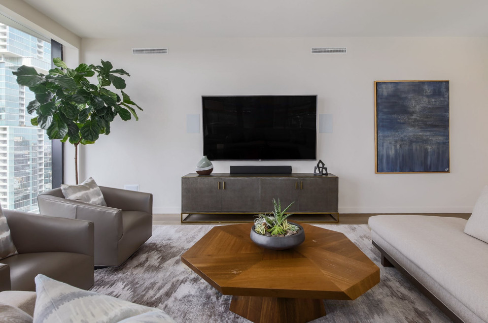 На фото: открытая гостиная комната среднего размера в стиле модернизм с белыми стенами, паркетным полом среднего тона, телевизором на стене и коричневым полом с