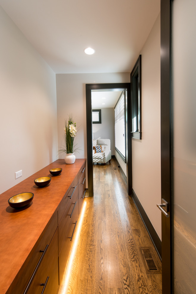 Example of a mid-sized transitional medium tone wood floor hallway design with white walls